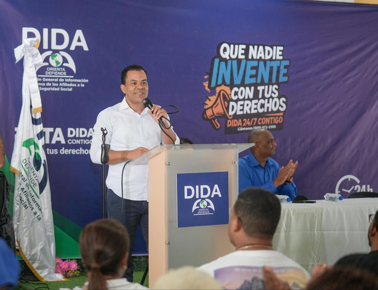 Director de la DIDA se dirige a los asistentes desde el podio durante la Ruta DIDA Contigo en Villa Altagracia, con el lema "Que nadie invente con tus derechos"