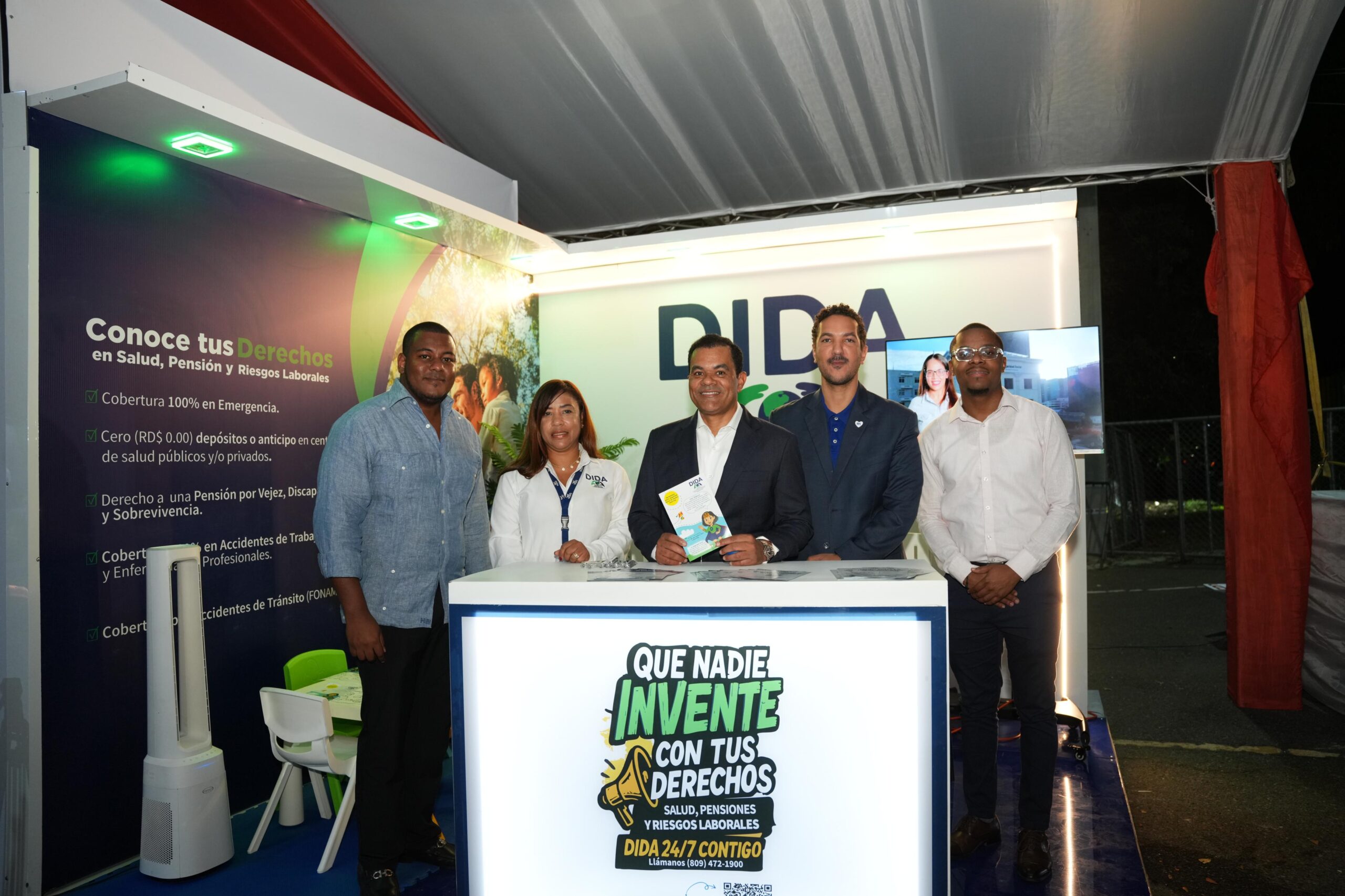 Director de la DIDA y colaboradores posan en el stand institucional de la DIDA en la Expo Cibao, con la campaña "Que nadie invente con tus derechos"
